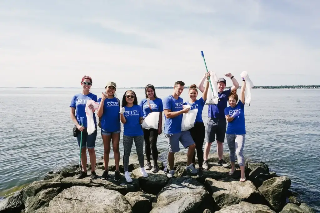 Rooftop Power team volunteers cleaning Save The Bay shoreline.