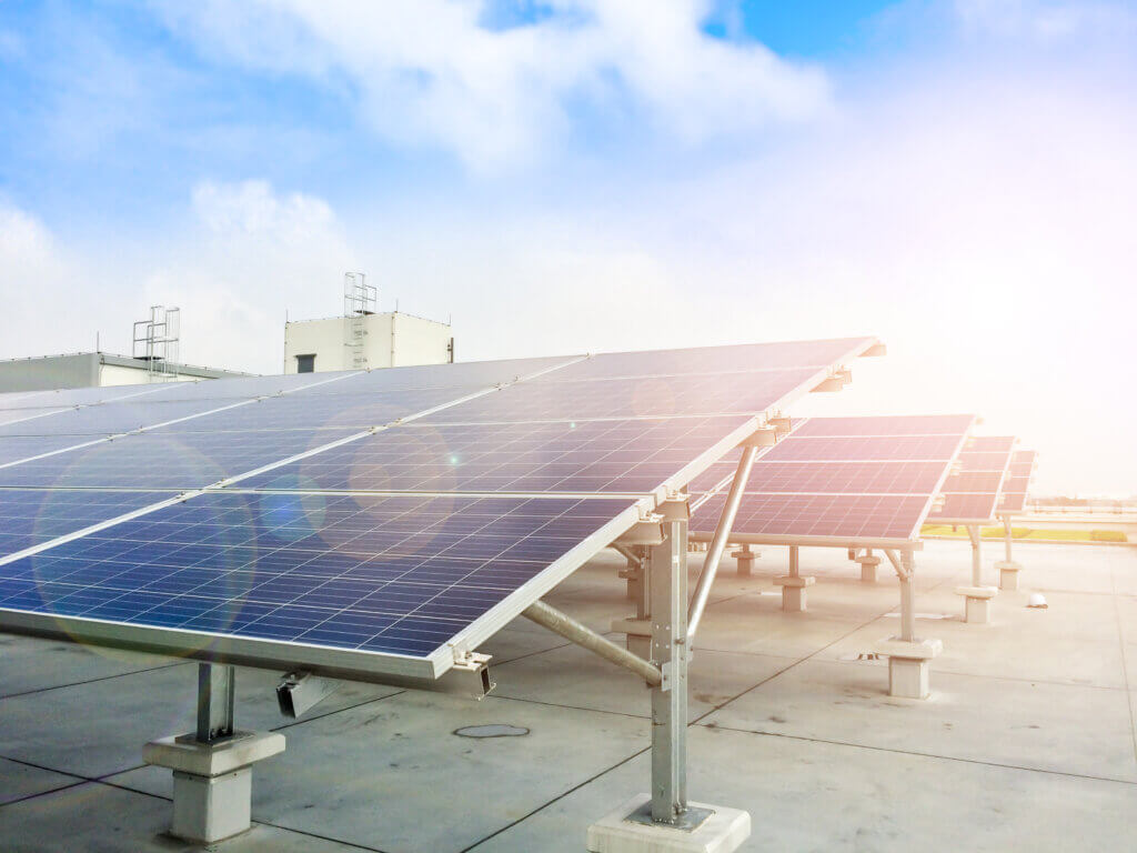 Solar panels on a rooftop generating electricity for electric vehicles.