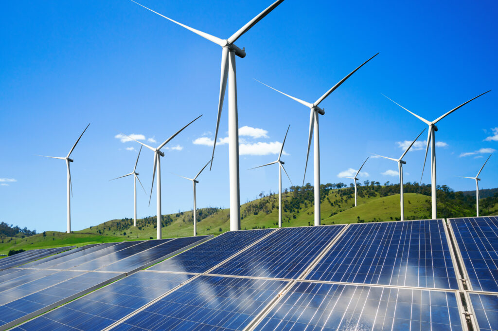 Wind turbines and solar panels illustrating renewable energy solutions.