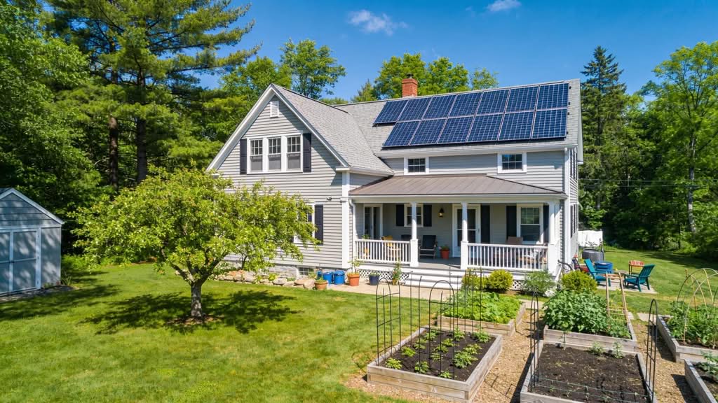 Massachusetts home with solar panels and a garden, illustrating solar energy adoption.