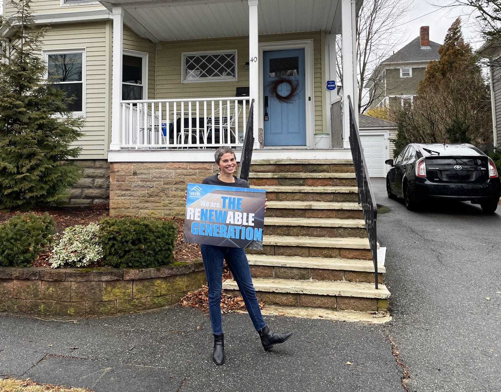 Providence homeowner with solar sign on a triple-decker house.